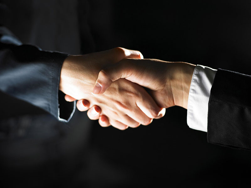 Zwei Menschen geben sich die Hand