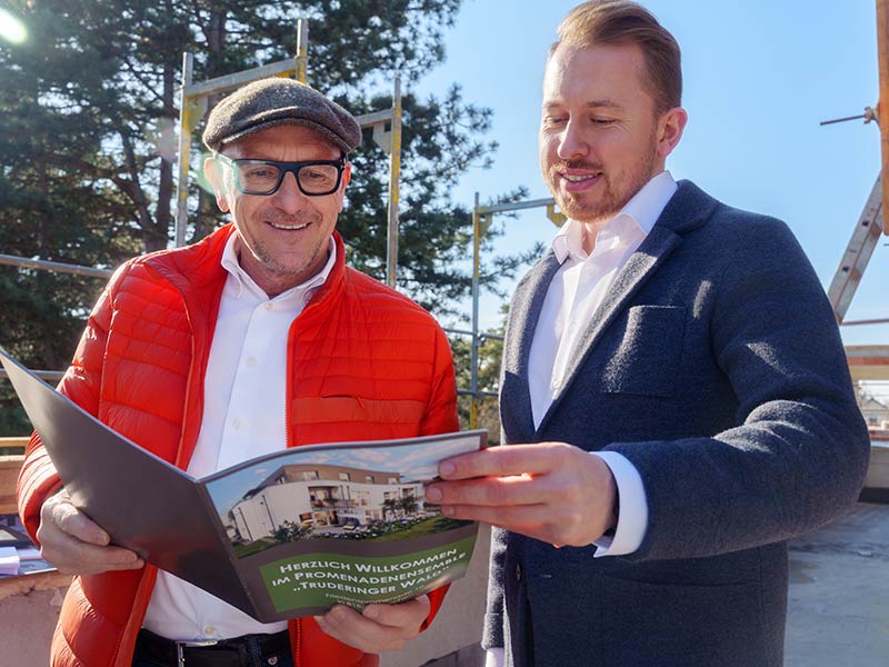 Für uns zählt Partnerschaftlichkeit Norbert Gruber mit Kunde und Immobilienprospekt